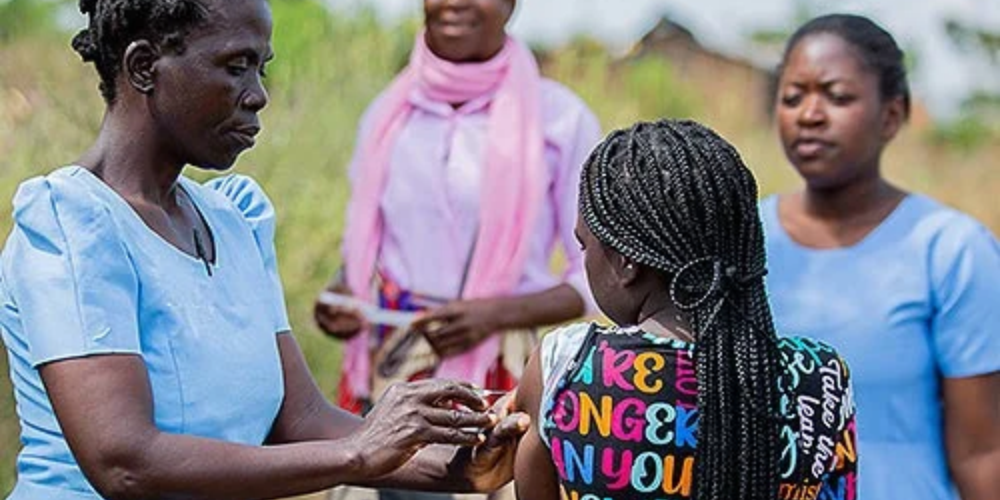 A nurse gives a young girl a shot in the arm