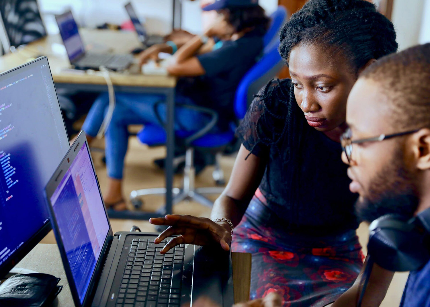 Two people at a computer reviewing code