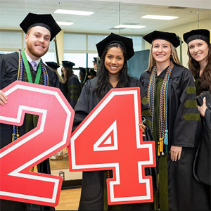 Group of graduates holding the numbers 2 and 4.