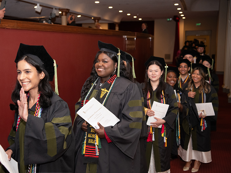 Line of UMB Pharmacy Students walking to receive their degrees.