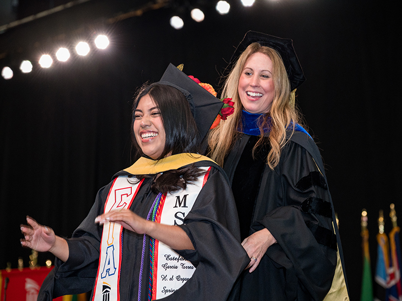 UMB School of Social Work Graduate being hooded by a faculty member.