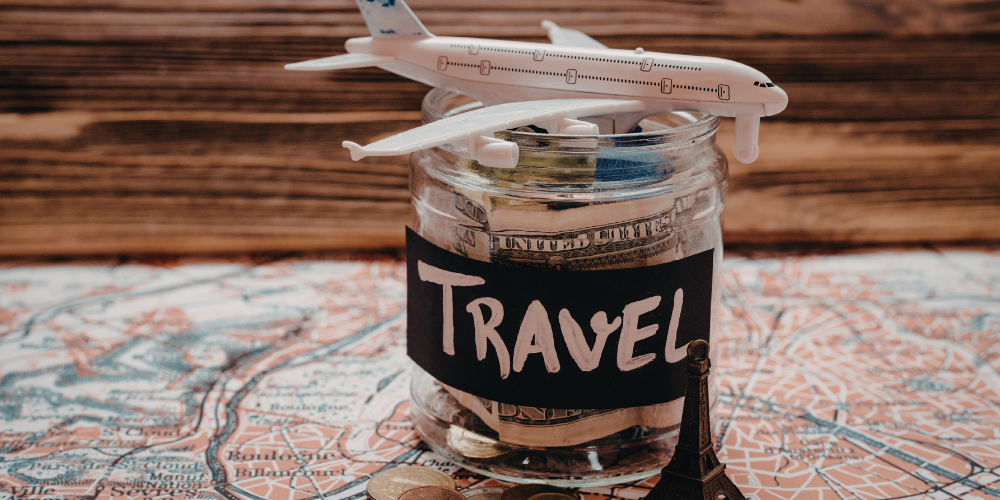 A toy airplane sits on a jar with money on top of a map