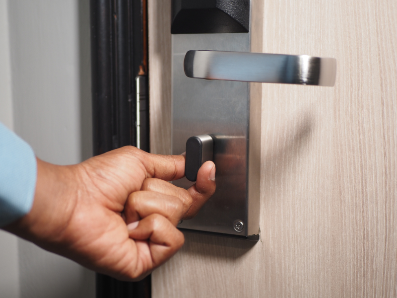 A hand locks a hotel door