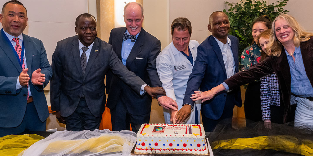 UMB and SOM faculty and staff cut a cake to celebrate the launch of the Global Health Alliance.