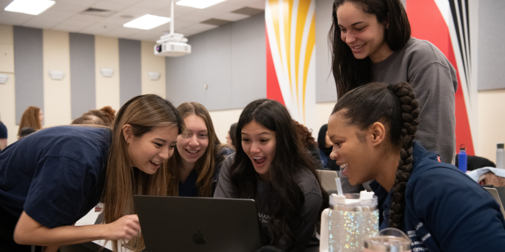 Students work together at a laptop