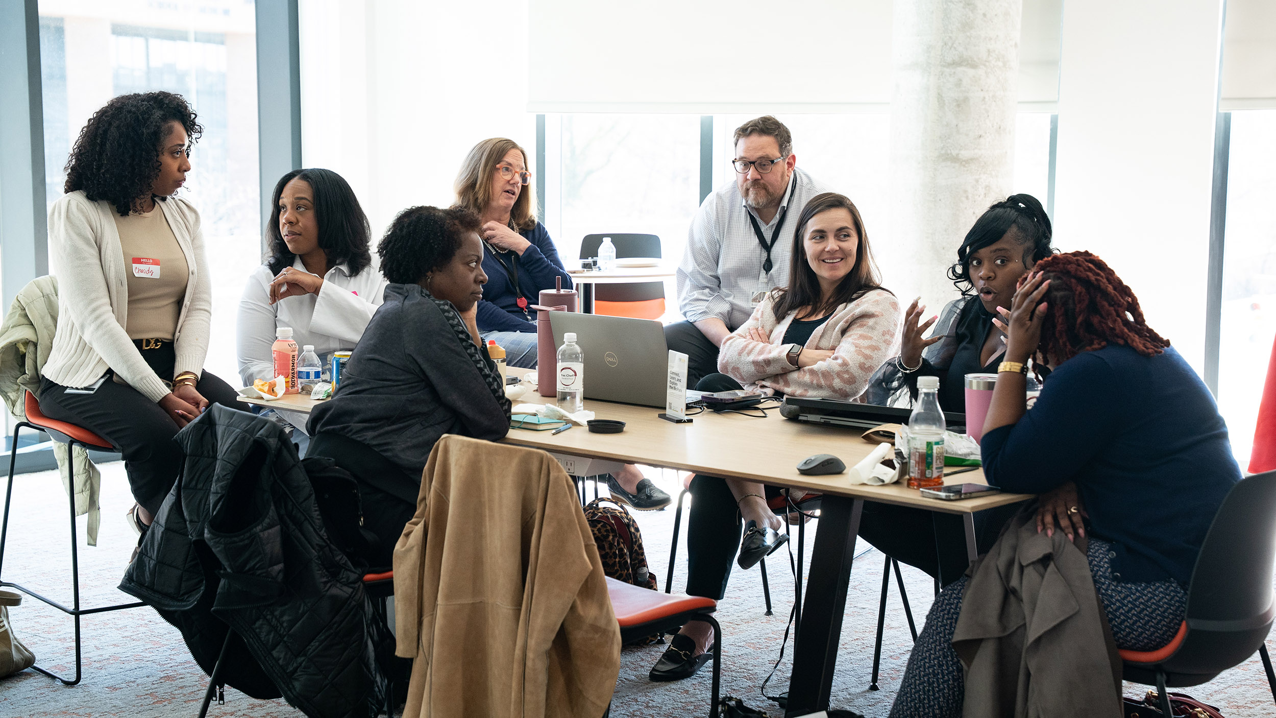a group of diverse professional have a discussion around a table