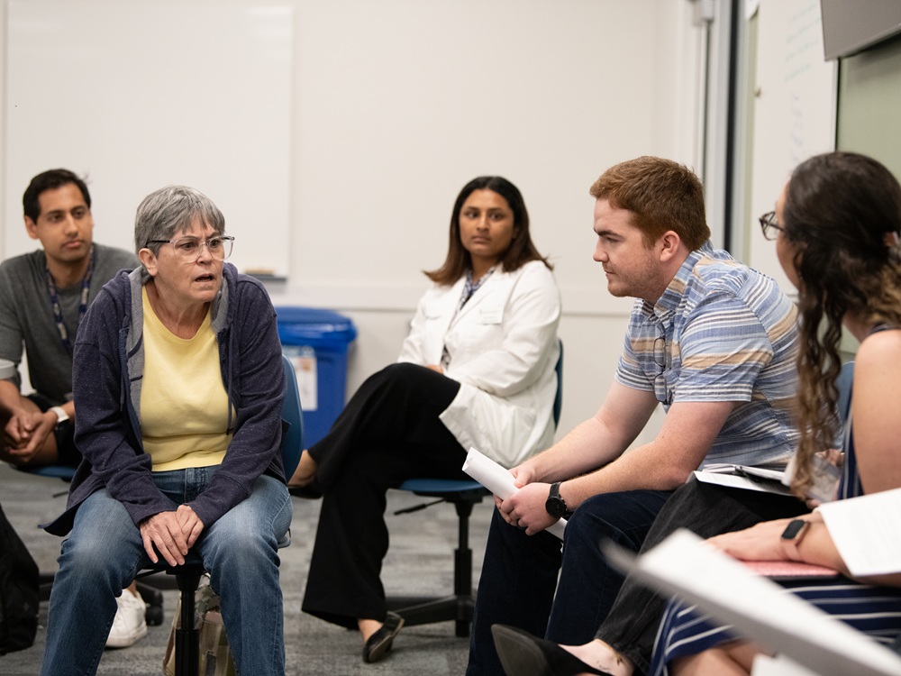 Students from schools across UMB's campus interview a breakout simulation session.