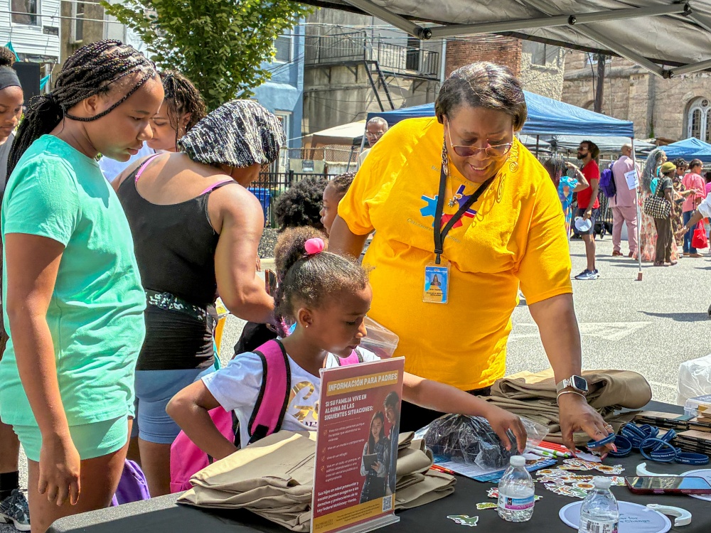 A girl selects stickers and supplies from the Baltimore City Public Schools table at the fifth annual Back-to-School Bash. Photo by Charles Schelle