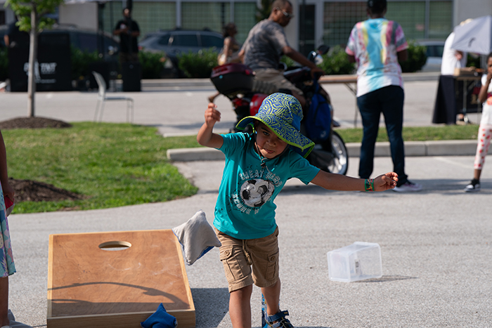 A young participant tests their aim tossing a bean bag at one of several games featured at the Juneteenth Jubilee.