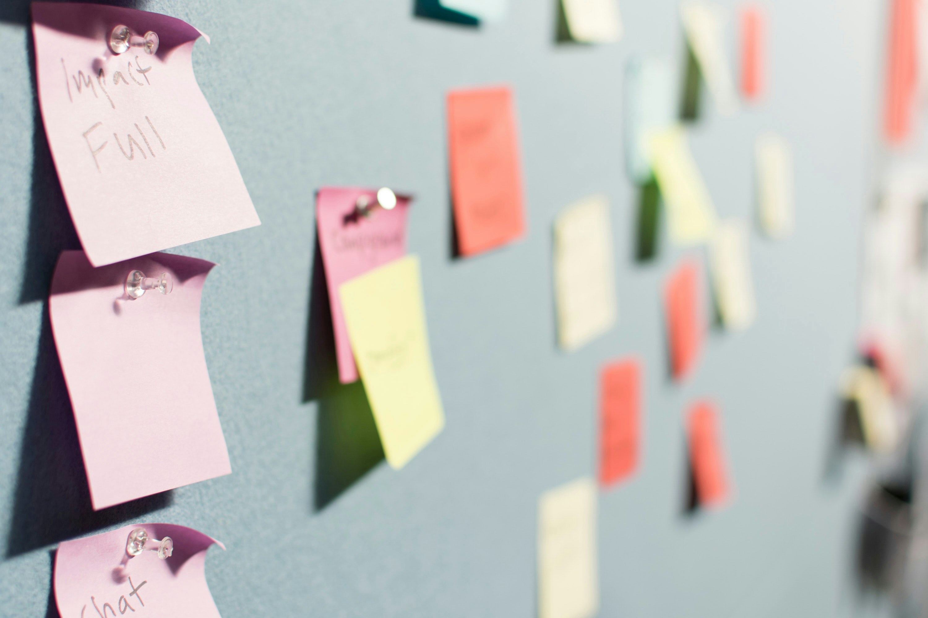 A wall with differently colored sticky notes